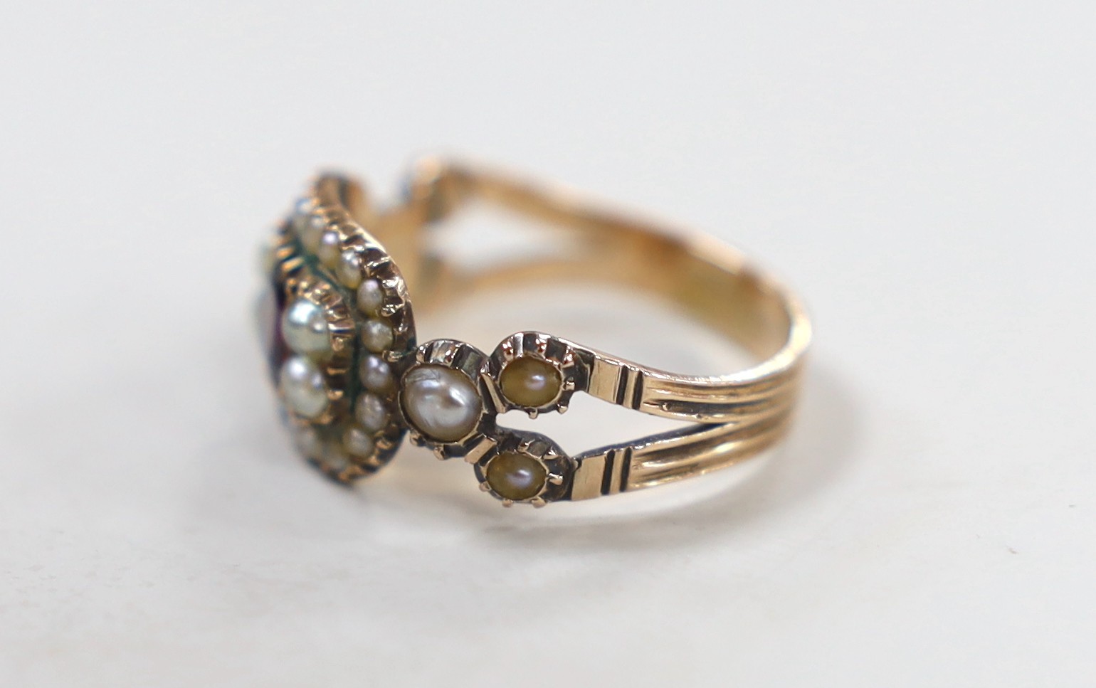 A 19th century yellow metal, foil backed? garnet and split pearl set ring (repair), size O/P, gross 3.6 grams.
